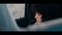 a woman sitting in a car looking out the window