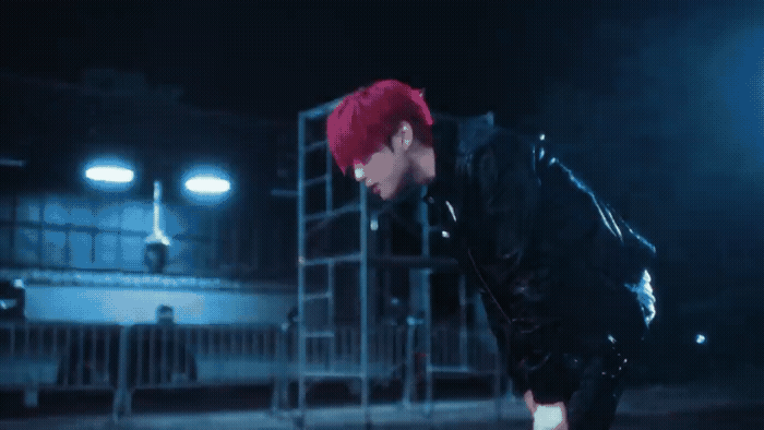 a young man with red hair and a black jacket