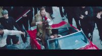 a group of people standing around a red car