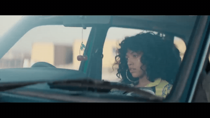 a woman sitting in a car looking out the window
