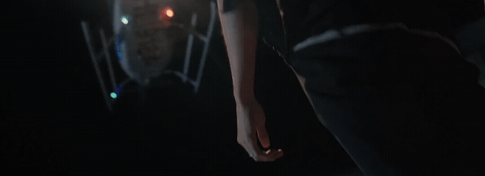 a person standing in the dark with their hand on their hip