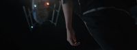 a person standing in the dark with their hand on their hip