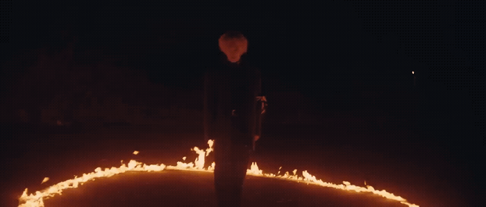 a man standing in the middle of a circle of fire