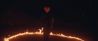 a man standing in the middle of a circle of fire