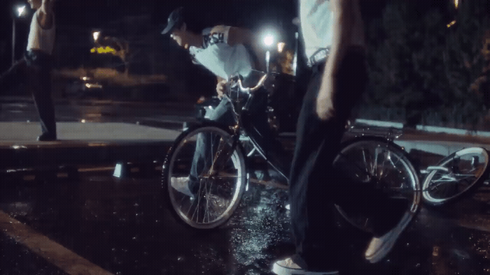 a man riding a bike down a street at night