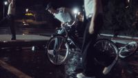 a man riding a bike down a street at night