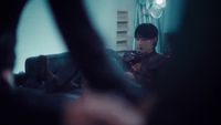 a man sitting on a couch playing a violin
