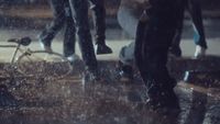 a couple of people walking down a street in the rain