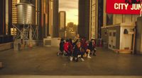 a group of kids standing in a circle in a city