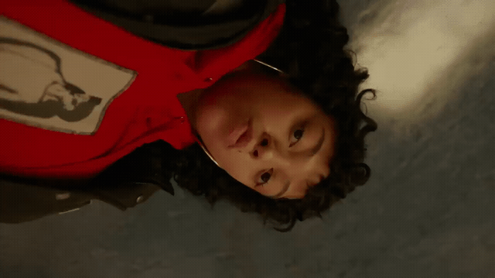 a man with curly hair wearing a red shirt