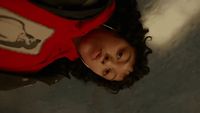 a man with curly hair wearing a red shirt