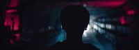 a silhouette of a person in a dark tunnel