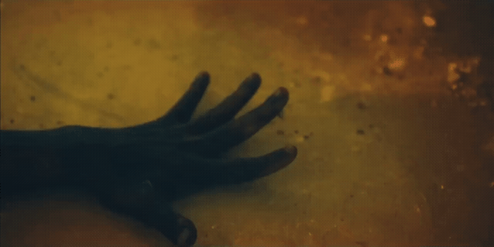 a person's hand on the ground with dirt on it