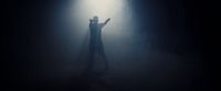 a person standing in the dark with their arms outstretched