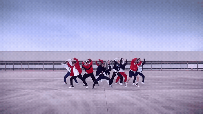 a group of people standing on top of a cement field