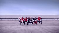 a group of people standing on top of a cement field