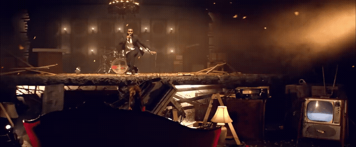 a man standing on top of a pile of furniture