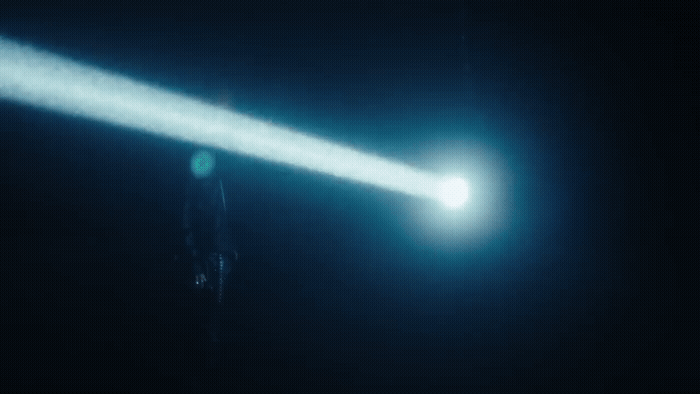 a person standing in the dark holding a flashlight