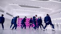a group of men in suits and sneakers walking in a room