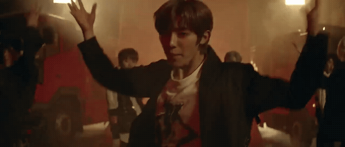 a man standing in a room with his hands up
