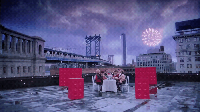 a group of people sitting at a table on top of a roof