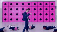 a man standing in front of a pink wall