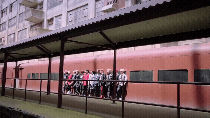 a group of people standing on a platform next to a train