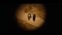 two women walking down a dirt road at night