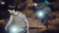a man riding a bike down a street at night