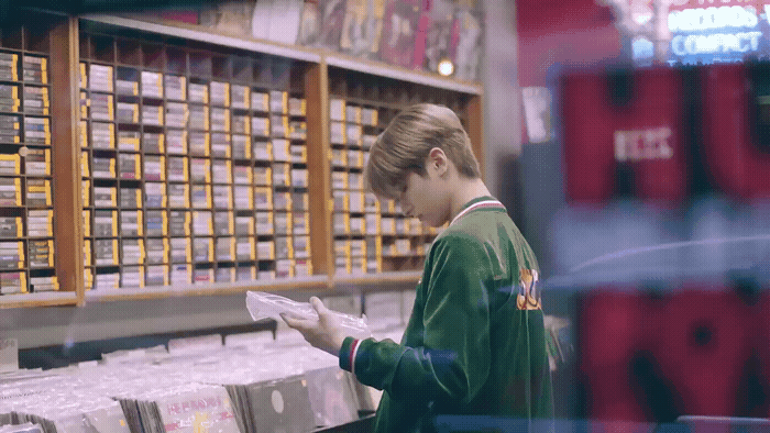 a woman standing in a store looking at a piece of paper