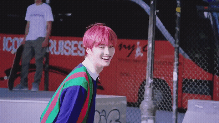 a person with pink hair and a colorful shirt