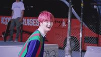 a person with pink hair and a colorful shirt