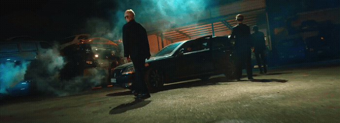 a group of men standing next to a car