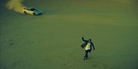 a person standing in the middle of a field next to a car