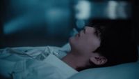 a man laying in bed with his eyes closed