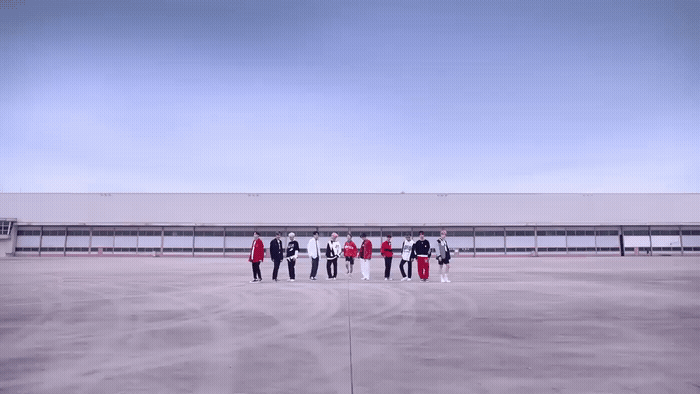 a group of people standing in a parking lot