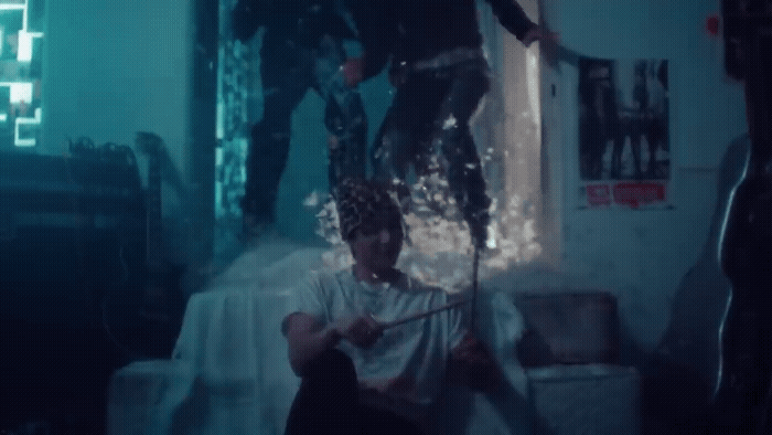 a man sitting in a chair while another man stands on top of him