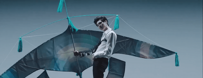 a man is holding a kite shaped like a shark