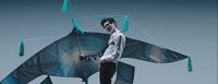 a man is holding a kite shaped like a shark