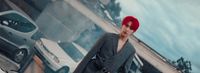 a woman with red hair standing in front of a painting