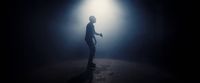 a man standing in a dark room with a light shining on him