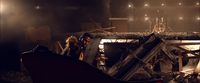 a man standing next to a pile of rubble in a dark room