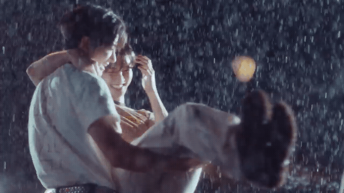 a man holding a woman in the rain
