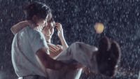 a man holding a woman in the rain
