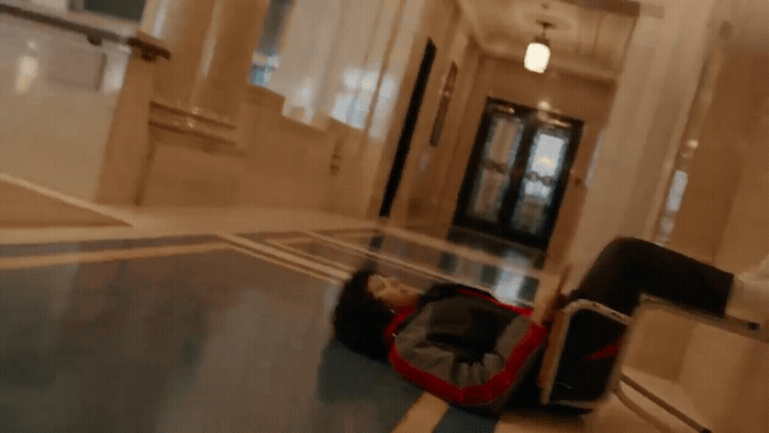 a person laying on the ground in a hallway