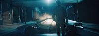 a man standing next to a car in the dark