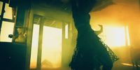 a person standing in a room with a fire in the background