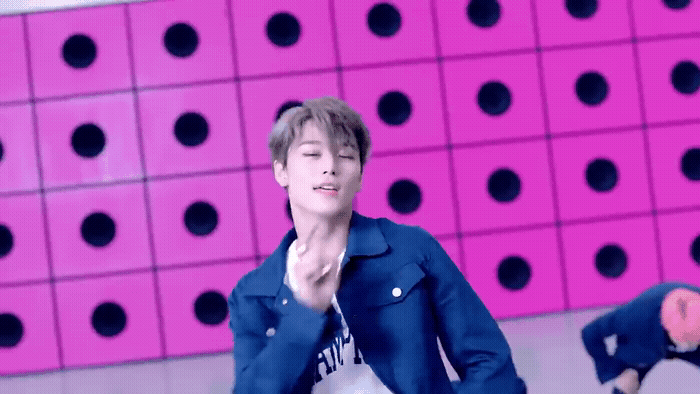 a man standing in front of a pink wall
