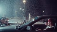 a woman driving a car in the rain at night