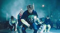 a group of young men riding skateboards down a street